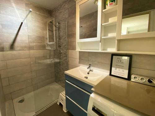 une salle de bain avec un lavabo et une douche dans l'établissement Le Sidonie, à Luchon