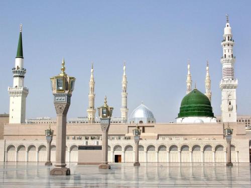 a large building with a mosque with a green dome at فندق سما المدينة in Al Madinah