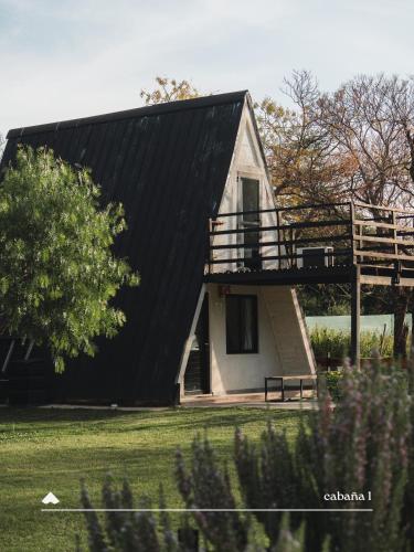 a house with a black roof and a porch at COMPLEJO ISABELLA in Villa Amancay