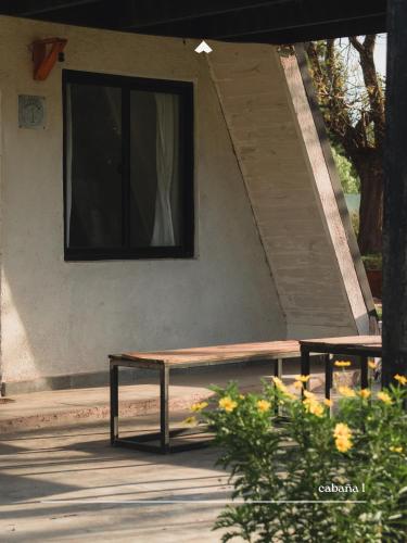 a bench in front of a building with a window at COMPLEJO ISABELLA in Villa Amancay