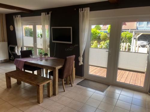 comedor con mesa, sillas y puertas correderas de cristal en Haus Brekersmeden, en Zingst