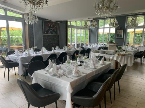 a dining room with tables and chairs and chandeliers at Areal Botanika in Unhošť