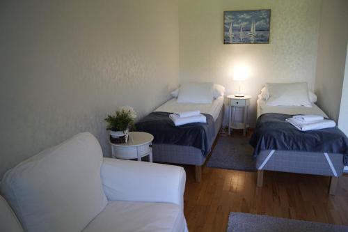 a small room with two beds and a couch at Apartments Borg Annikki in Pori