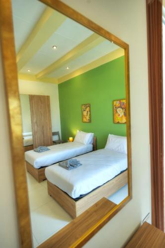 a mirror reflection of a bedroom with two beds at Britannia Suites, charming 2 bedroom flat JCAS2 in Il-Furjana