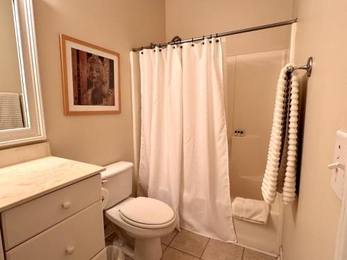 un bagno bianco con wc e doccia di Loft-Style Gem in 1911 Building a Elloree