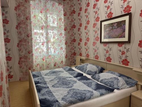 ein Schlafzimmer mit einem Bett und einem Fenster mit Blumentapete in der Unterkunft Apartment Sadova Karlovy Vary in Karlsbad