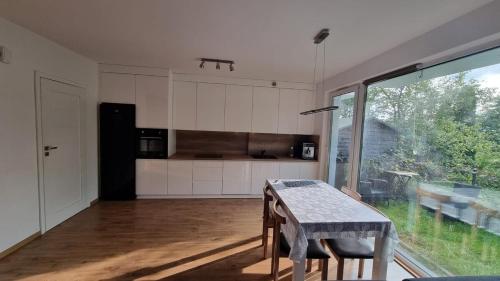 een keuken met een tafel en een groot raam bij Apt blisko morza in Kosakowo