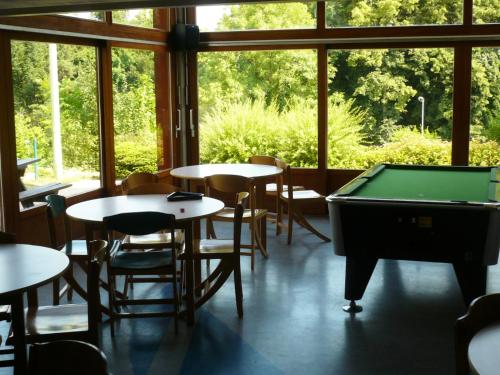 une chambre avec des tables et un billard dans l'établissement Auberge de Jeunesse HI Annecy, à Annecy
