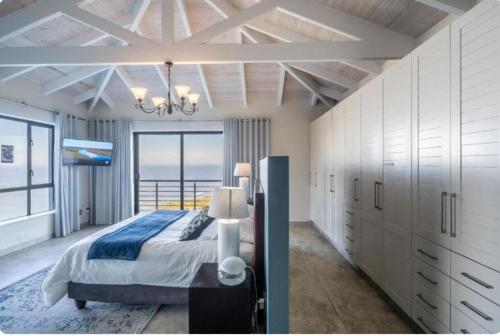 a bedroom with a bed and a view of the ocean at Breakwaters Haven - Luxury Villa Pezula in Knysna
