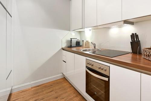 a kitchen with white cabinets and a sink at 6 rooms in Vienna