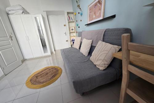 un salon avec un canapé gris et une table dans l'établissement Charming studio in the crest, à Nîmes