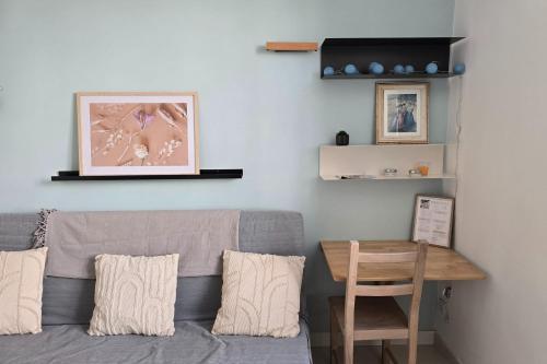 - un salon avec un canapé gris et une table en bois dans l'établissement Charming studio in the crest, à Nîmes