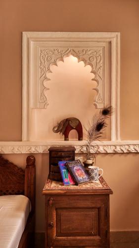 a table with books on it next to a bed at The Castle View Homestay in Būndi