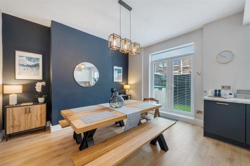 a dining room with a table and a blue wall at Watford Lodge - Air Host & Stay - A Home in the Heart of Anfield in Liverpool