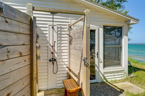 a wooden door with a bench in front of a house at Sunny Mears Vacation Rental with Private Beach! in Mears