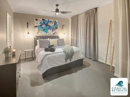 a bedroom with a bed and a painting on the wall at Mani Manor - Coastal Retreat - Linen Included in Cowes