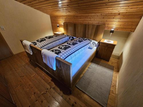 a large bed in a room with a wooden ceiling at Der Alpenfrieden in Marul