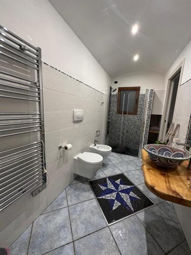 a bathroom with a toilet and a sink and a shower at Le pietre di Mario in Bari Sardo