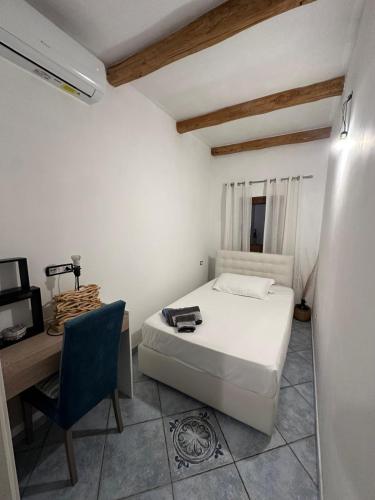a bedroom with a bed and a desk and a chair at Le pietre di Mario in Bari Sardo