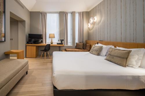 a hotel room with a large bed and a desk at Descobertas Boutique Hotel by Aspasios in Porto