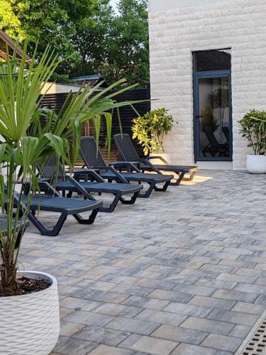 a row of lounge chairs sitting on a patio at POOL RESORT- Vila Lena- Studio 3 in Vrdnik