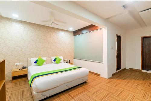 プネにあるHotel Juglans Innのベッドルーム1室(大型ベッド1台、大画面スクリーン付)