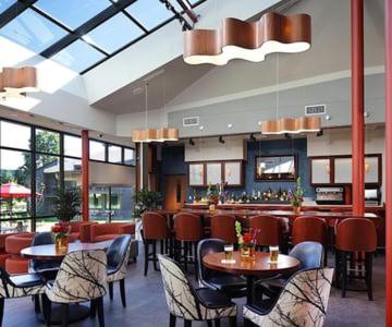a restaurant with tables and chairs and a bar at Chauncey Hotel and Conference Center in Princeton