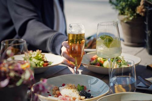 a table with plates of food and two glasses of beer at Lighthouse Hotel & Spa in Büsum