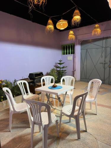 a white table and chairs and a table and a grill at Agréable maison près de la plage in Aglou