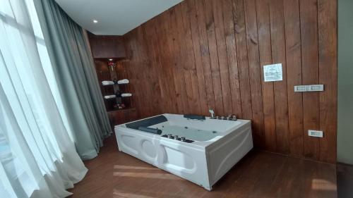 a bathroom with a white tub in a wooden wall at Jewel Plaza and Aqua Park in Cairo