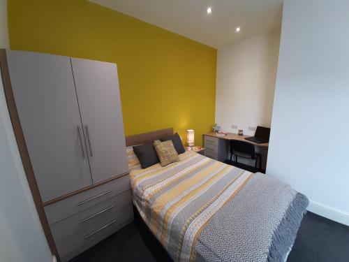 a bedroom with a bed and a dresser and a desk at Bright & Comfy 3-Bedroom Flat in Kexgill in Middlesbrough