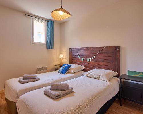 deux lits côte à côte dans une chambre dans l'établissement Maison de vacances avec piscine, à 2 pas de l'océan Atlantique, au Le Verdon-sur-Mer