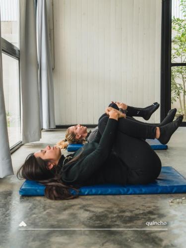 two women laying on the floor in a gym at COMPLEJO ISABELLA in Villa Amancay