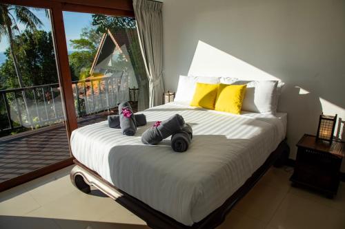 a bedroom with a large bed with a balcony at Baan Talay in Salad Beach