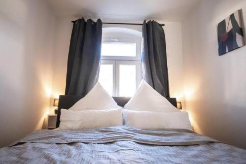 a bed with white pillows and a window at Auf dem Kassberg-Kanzler in Chemnitz
