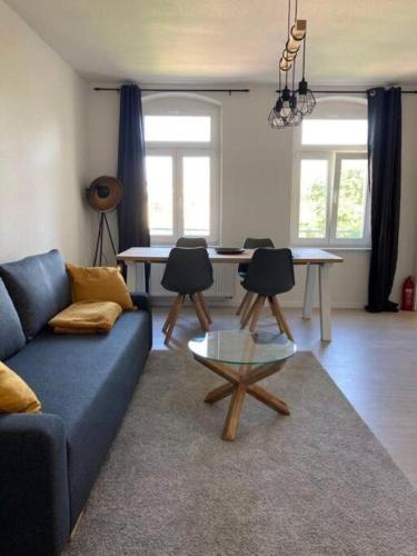 a living room with a blue couch and a table at Auf dem Kassberg-Kanzler in Chemnitz