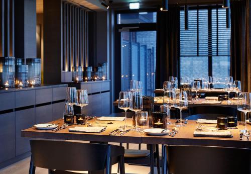 a restaurant with a long table with glasses on it at Lighthouse Hotel & Spa in Büsum