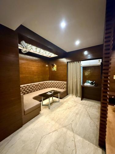 a room with a bench and a table in it at Hotel Ganpati in Siliguri