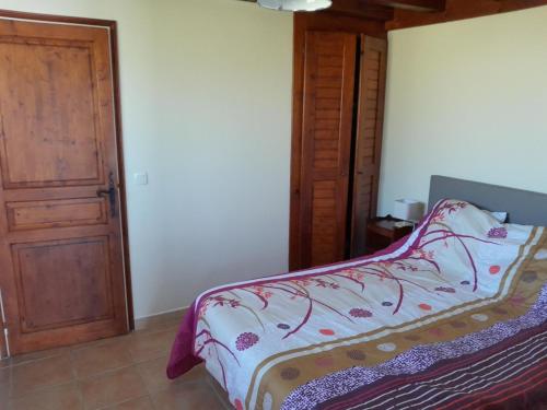a bedroom with a bed and a wooden door at Etxe ttikia in Ahetze