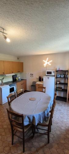une cuisine avec une table et une cuisine avec une table et des chaises dans l'établissement Appartement au pied des pistes, à Albiez-Montrond