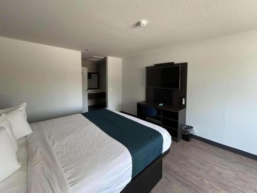 a hotel room with a bed and a flat screen tv at Studio 6 Lake Elsinore, CA in Lake Elsinore