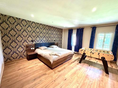 a bedroom with a bed and a wooden floor at Un moment hors du temps - Jacuzzi - Sauna - Billard -Baby-Foot- Parking - 167 in Rouen
