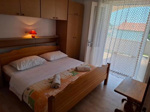 a bedroom with a bed with a large window at Guesthouse Goga in Rab