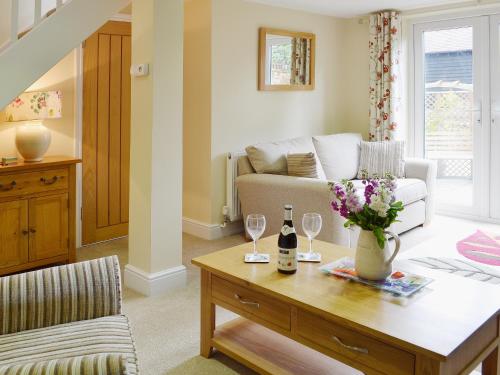 a living room with a couch and a table with wine glasses at Dairy Cottage in Matfield