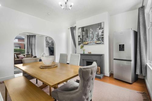 a living room with a table and a refrigerator at GuestReady - Charming Home in Vibrant Levenshulme in Manchester