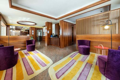 a lobby with purple chairs and a table at Best Western Hotel Nevada in San Vito di Cadore