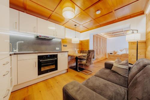 a living room with a couch and a kitchen at Zudrellhus in Silbertal