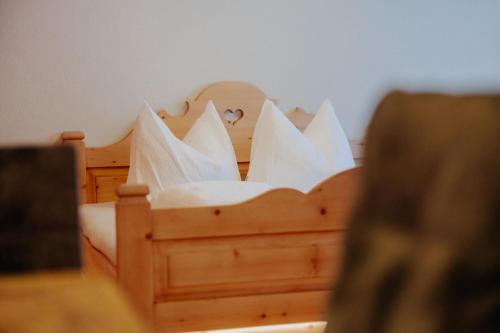 a bed with white pillows on top of it at Zudrellhus in Silbertal