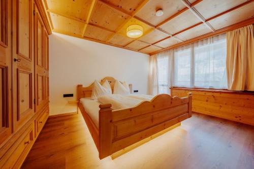 a bedroom with a wooden bed with a large window at Zudrellhus in Silbertal