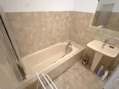 une salle de bain avec une baignoire et un lavabo dans l'établissement T1 climatisé avec parking à 700m des plages, animaux admis - FR-1-316-250, à Le Brusc